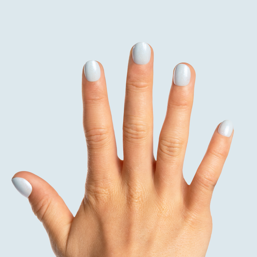 Snow Day - Pressies | Extra Short Short | Round showing pale blue sparkly press-on manicure on natural hand against light background