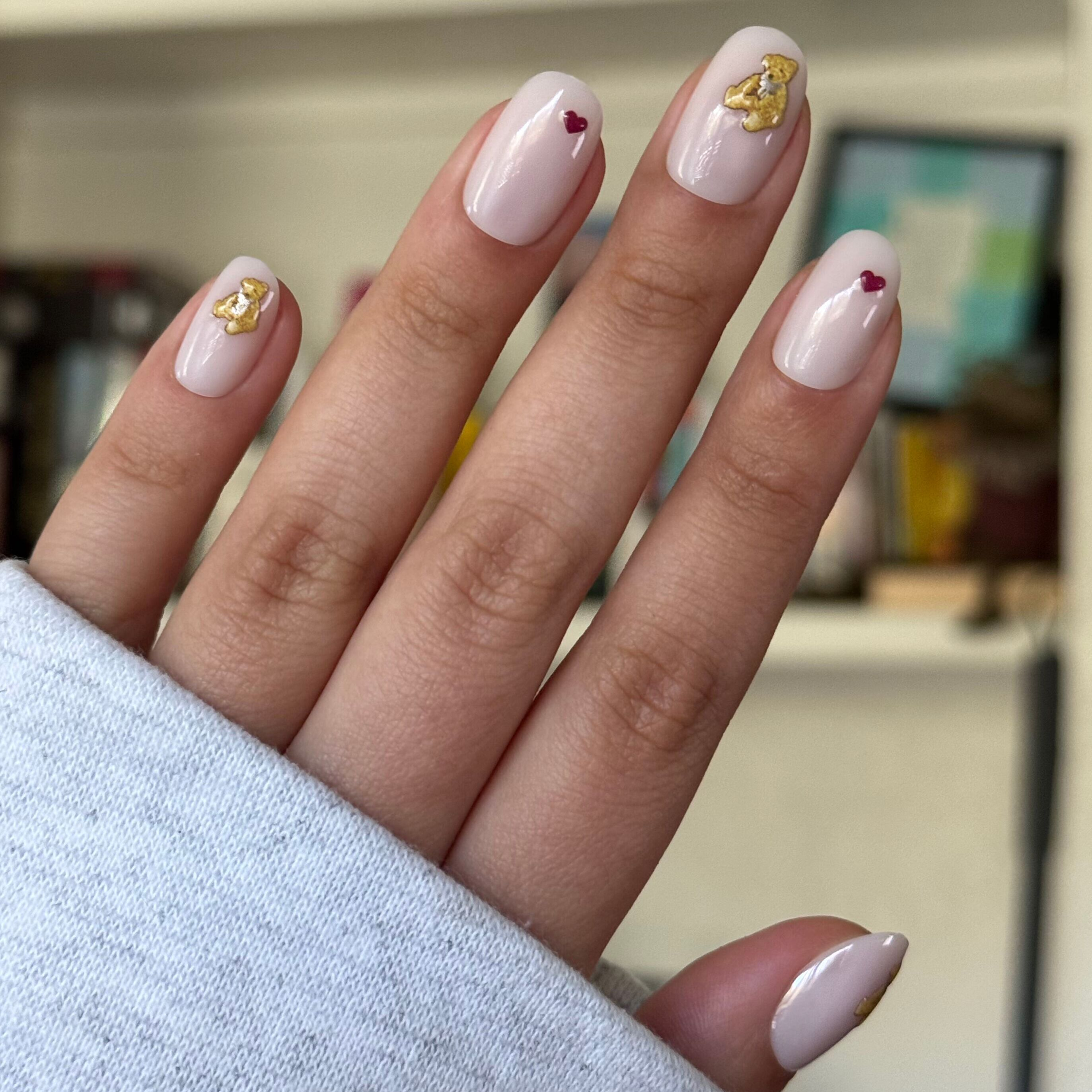 Tiny Teddy Hearts - Press On | Short | Round nails in soft pinky-beige with gold teddy and small red heart accents for a quick mani