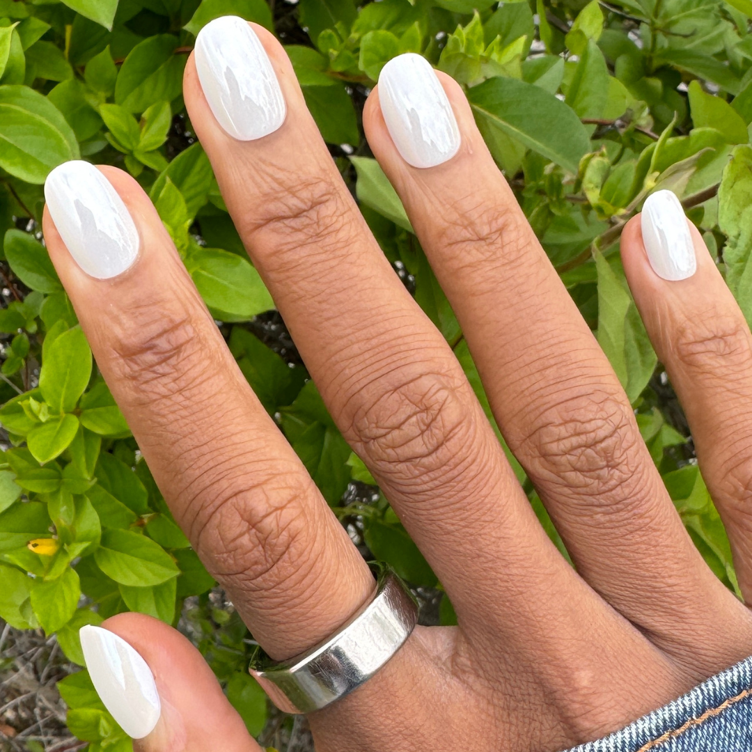 White Chrome - Press-On | Short | Round showing hand with short round white chrome press-on manicure outdoors