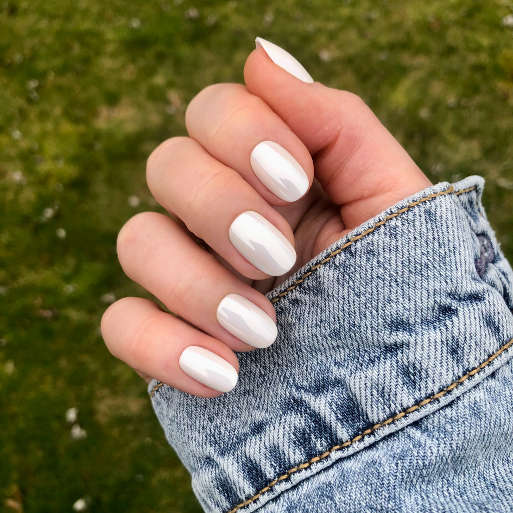 White Chrome - Press-On | Short | Round showing hand with short round glossy white chrome press-on manicure outdoors