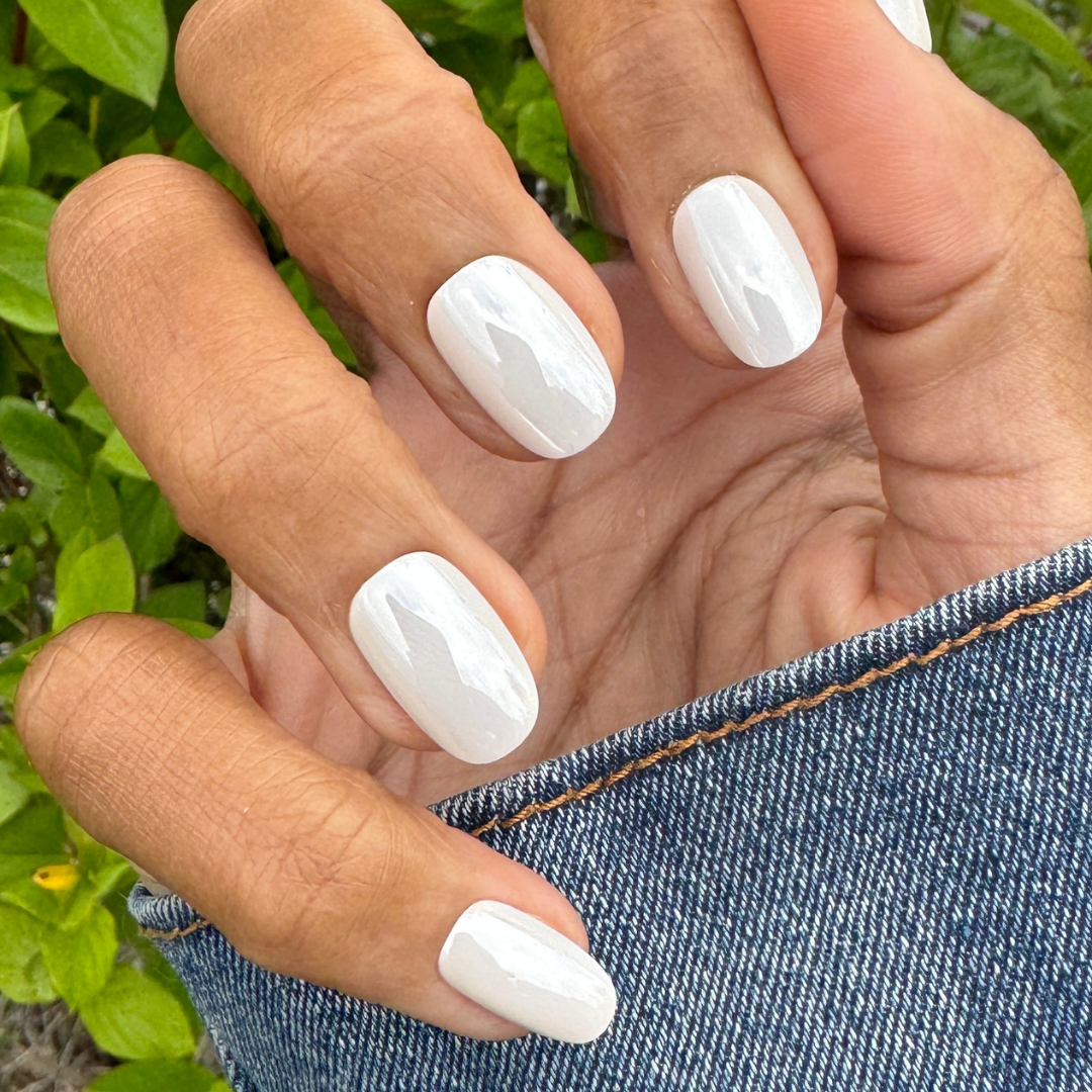 White Chrome - Press-On | Short | Round showing short round press-on nails with glossy white chrome manicure on natural hand outdoors