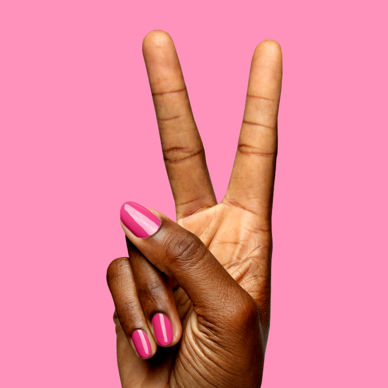 Hand showing peace sign with nails painted in bright magenta using Wild Orchid - Gel for bold, long-lasting manicure