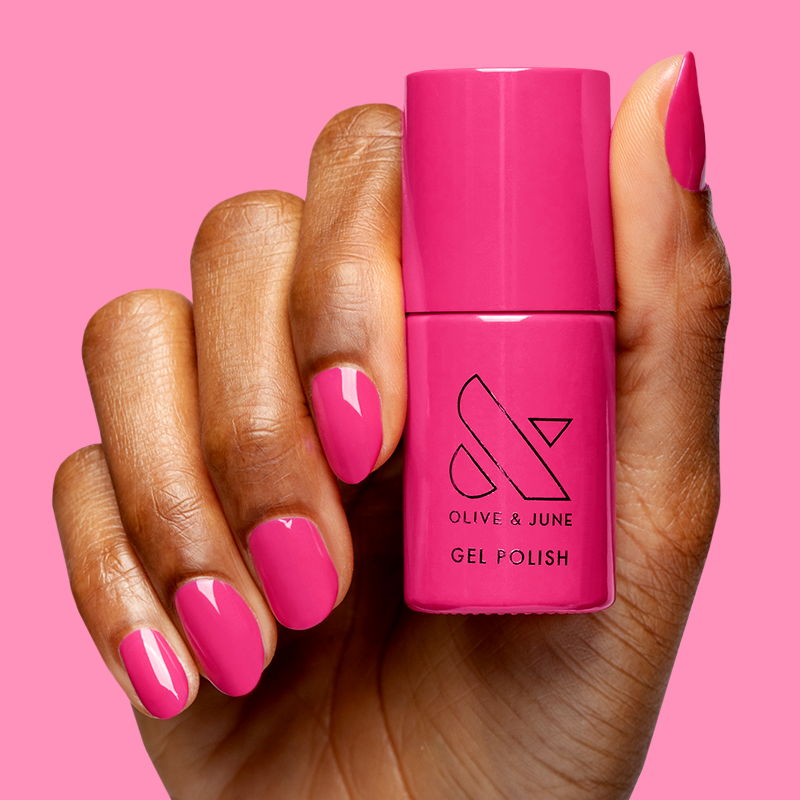 Hand holding Wild Orchid - Gel polish bottle with nails painted in vibrant magenta for a bold, long-lasting mani.