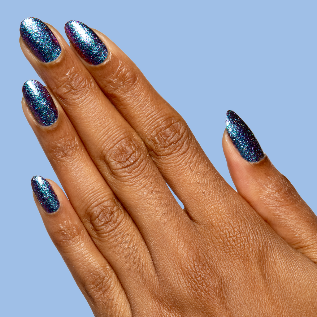 You Obviously Need It iridescent glitter polish with a purple-blue shift on medium almond-shaped nails for a sparkling mani