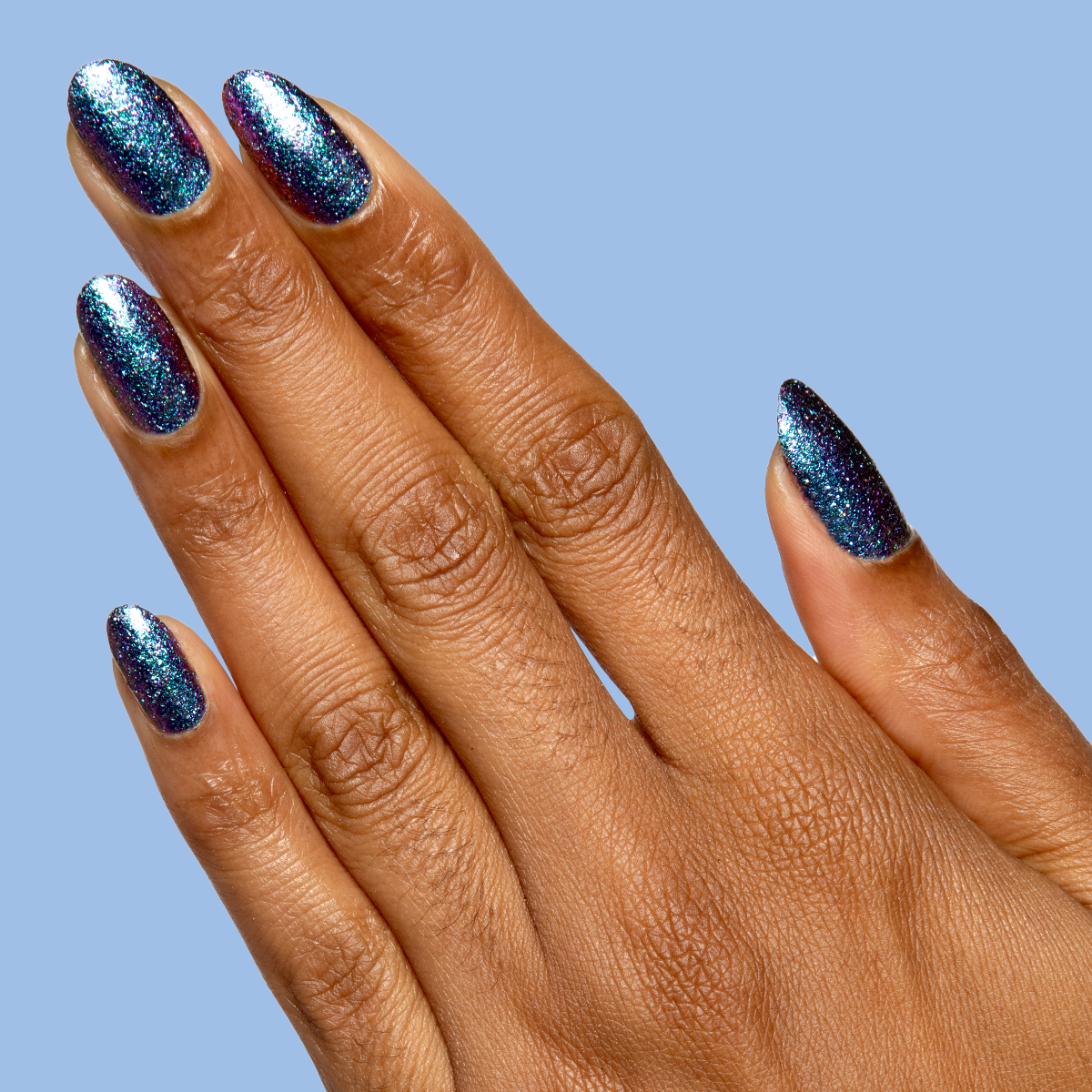 You Obviously Need It iridescent glitter polish with a purple-blue shift on medium almond-shaped nails for a sparkling mani