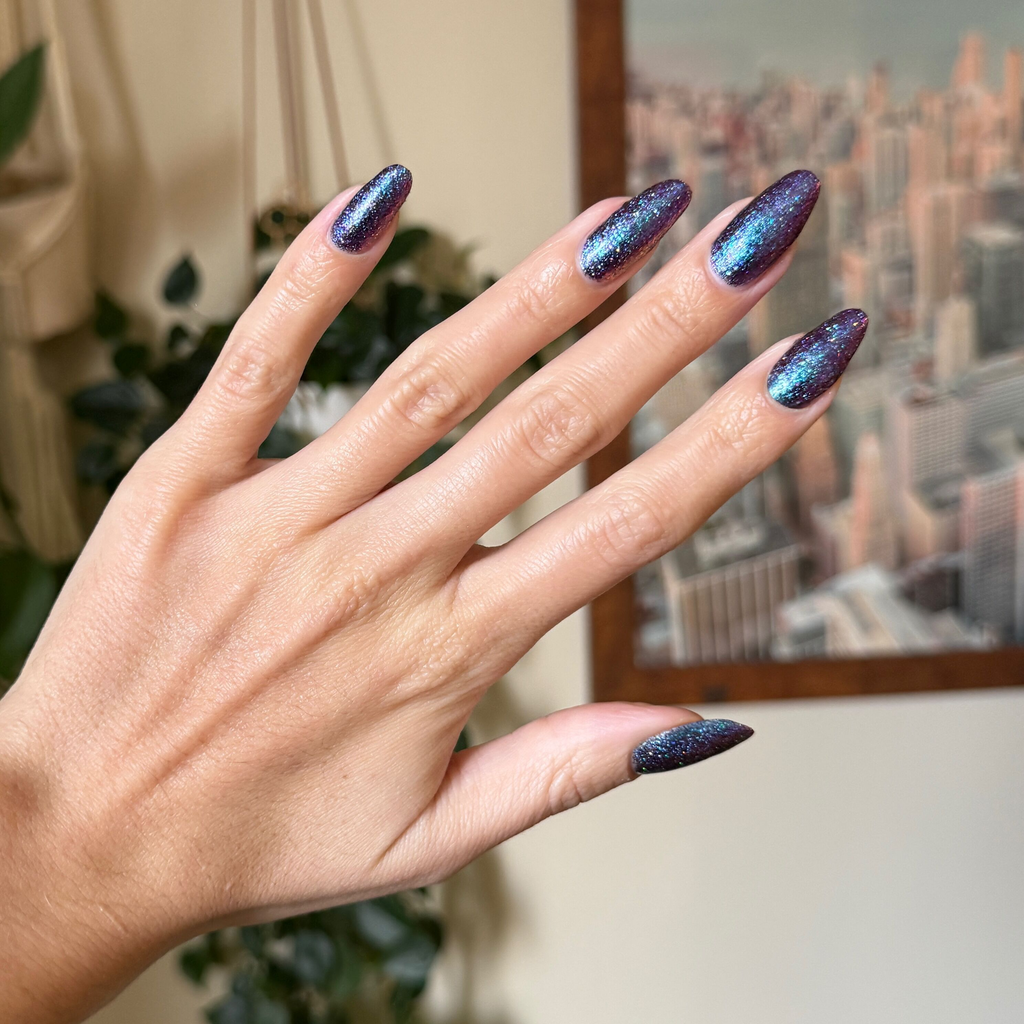 You Obviously Need It iridescent purple-blue glitter gel polish on long almond-shaped nails for a vibrant manicure