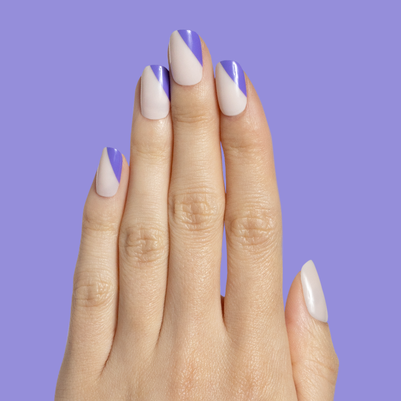 Asymmetrical French | Short | Squoval - Tab Press-On nails with indigo diagonal tips on natural base on hand against purple background