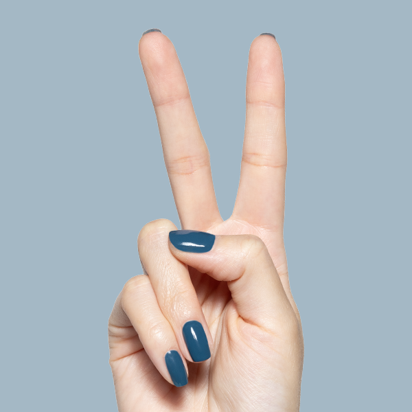 Hand displaying peace sign with glossy Bodysuit gel polish manicure in dusty cool teal on medium-length nails against blue background