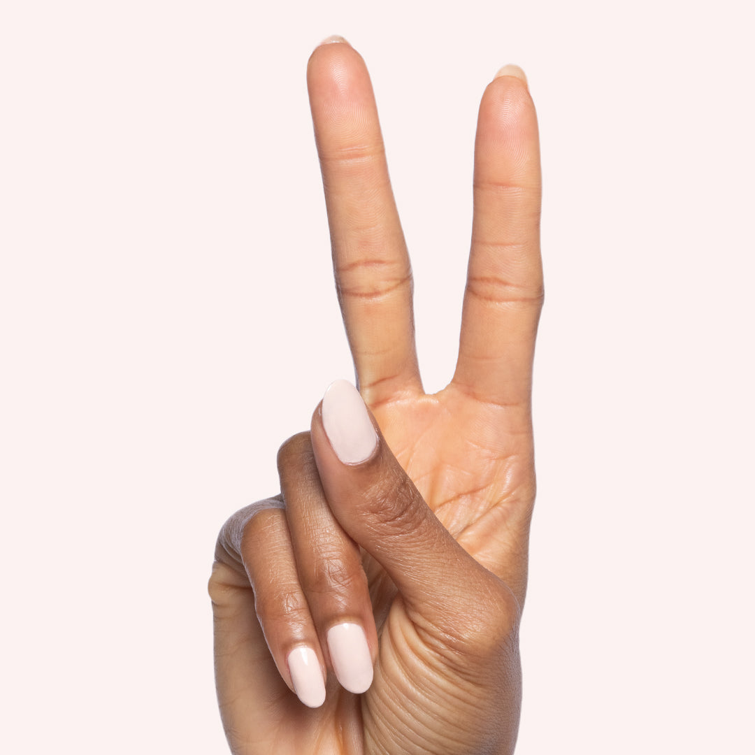 hand showing peace sign with cold foam pls nail polish in shimmery neutral beige for elegant manicure