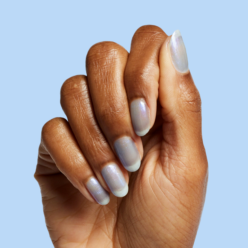 Hand with nails painted in cool lavender-blue iridescent manicure using Friend or Anemone? gel polish on blue background