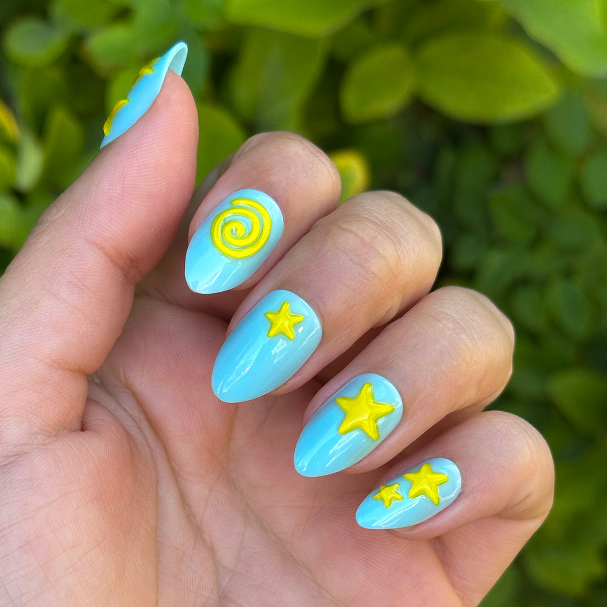 Fun Zone - Press-On | Medium | Almond with bright blue polish and raised yellow star and spiral designs for an at-home mani