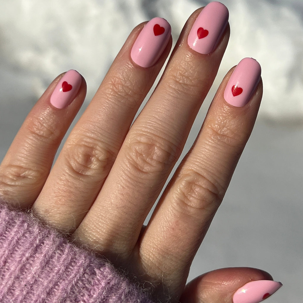 Pink Perfect Heart - Press-On | Round | Short with soft pink base and red heart detail on natural nails in natural light