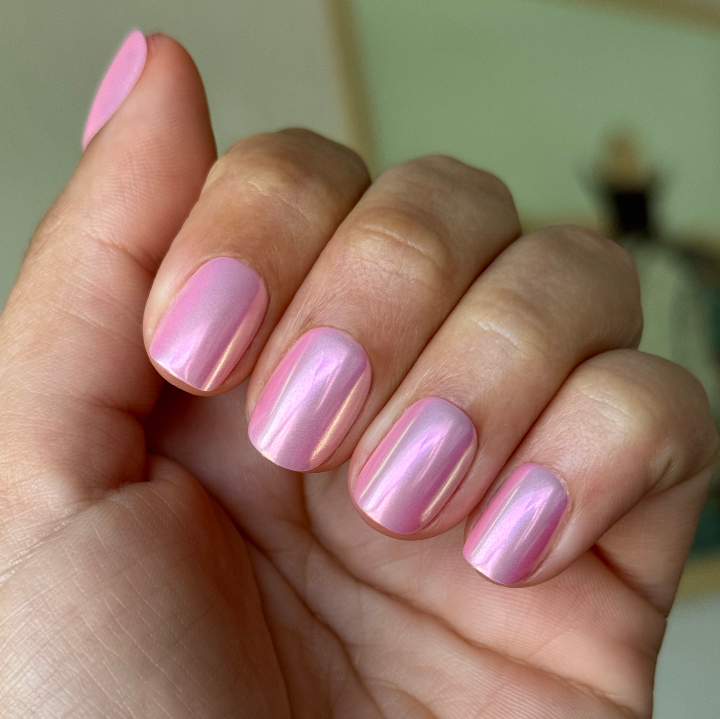 Pink Rainbow Chrome - Press-On | Extra Short | Squoval iridescent pink false nails on hand with natural indoor lighting