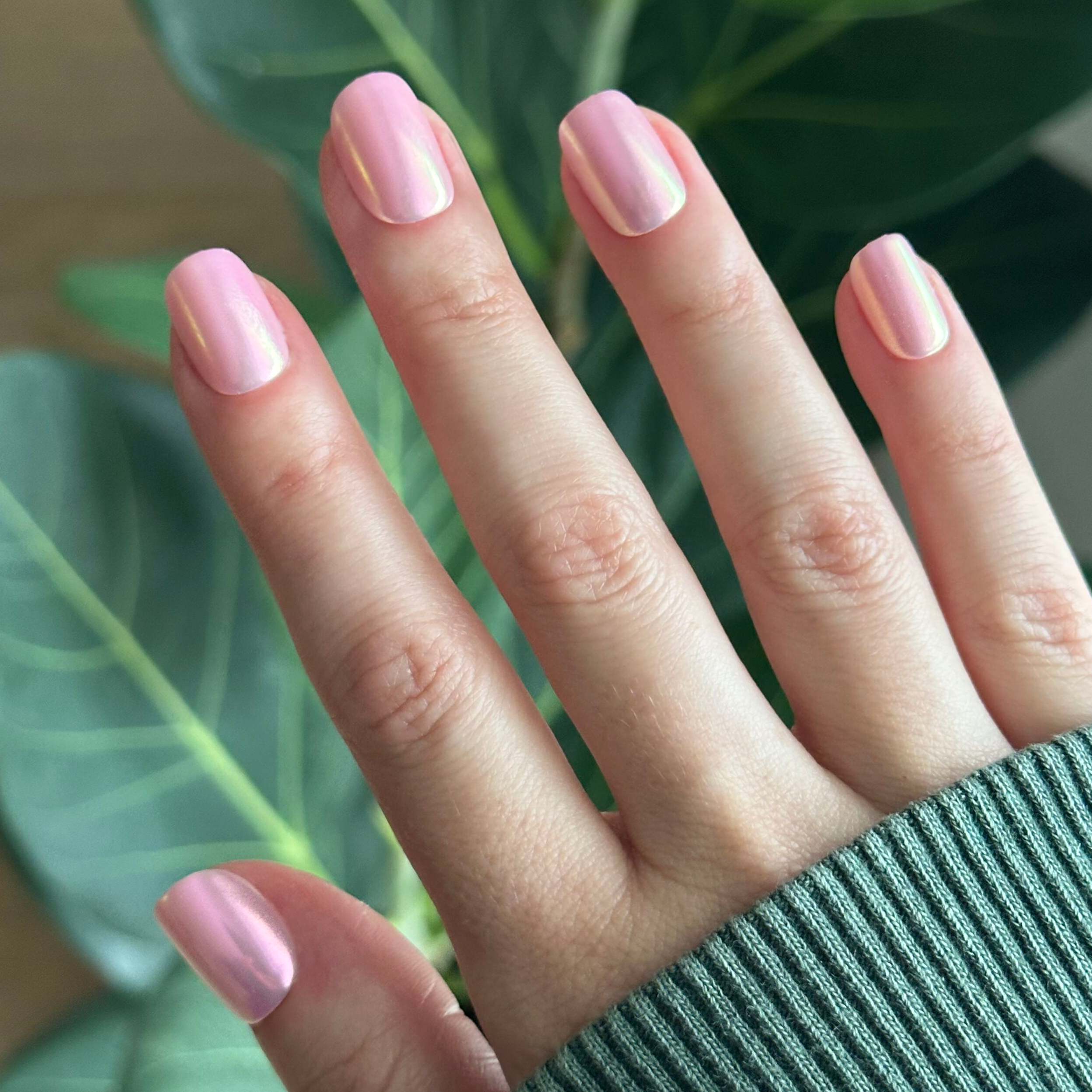 Pink Rainbow Chrome - Press-On | Extra Short | Squoval iridescent pink false nails shown on hand with natural leaf backdrop