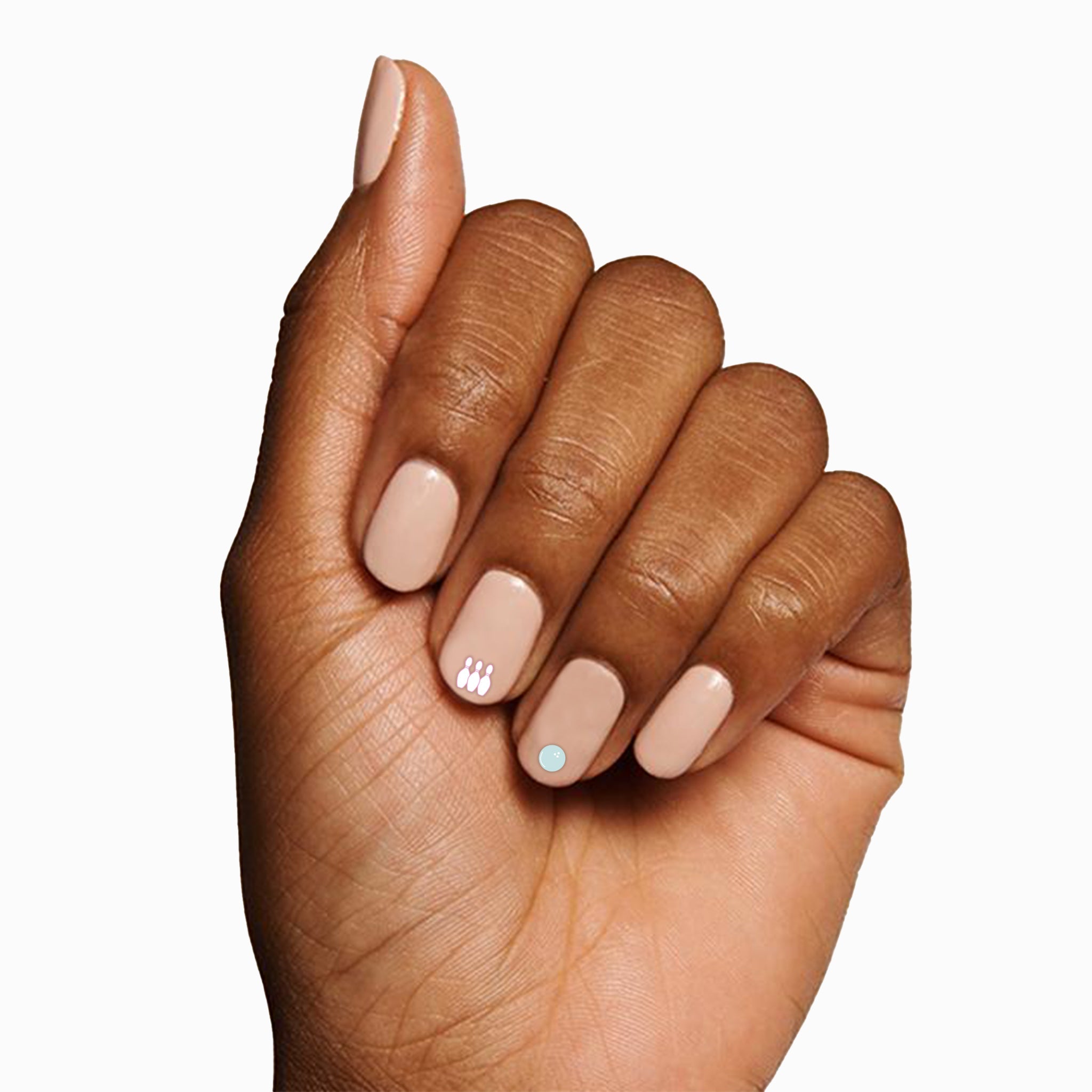Hand with neutral polish and subtle white and blue Sports Pack nail stickers for a sporty manicure look