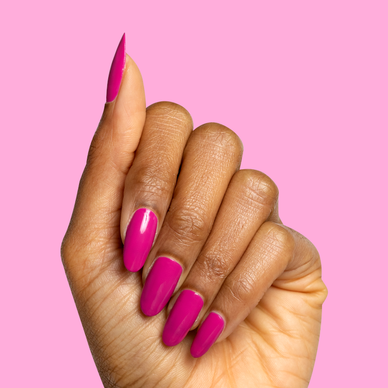 Hand with medium-length nails painted in bold orchid magenta Wildest gel polish showing glossy, vibrant manicure against pink background